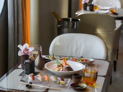 Frisch zubereitetes Sushi und Sashimi auf einem stilvoll gedeckten Tisch im Restaurant an Bord der Seabourn Ovation.