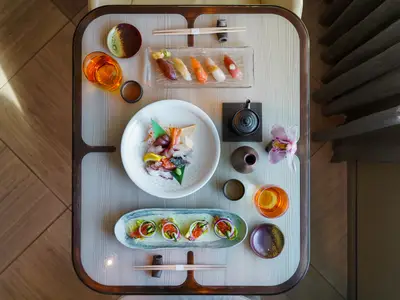 Eine stilvolle Draufsicht auf frisches Sushi, Sashimi und Sake an Bord der Seabourn Ovation.