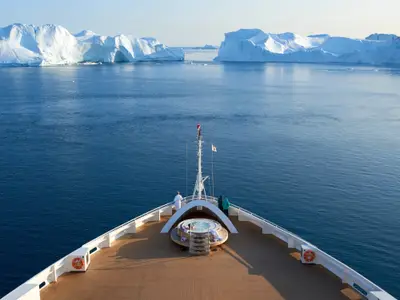 Vogelperspektive auf den Bug der Seabourn Quest mit Whirlpool und Gästen inmitten arktischer Gletscher.
