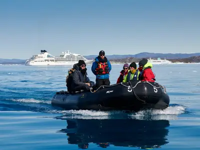 Passagiere in einem Zodiac-Boot bei einer Exkursion vor Grönland, im Hintergrund die Seabourn Quest.