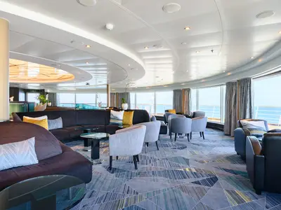Die modern eingerichtete Lounge an Bord der Seabourn Quest bietet gemütliche Sessel und einen Panoramablick auf das blaue Meer.