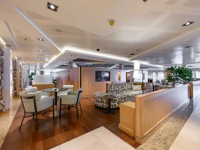 Blick in den großzügigen, modern gestalteten Loungebereich Seabourn Square an Bord der Seabourn Quest mit bequemen Sitzgruppen.