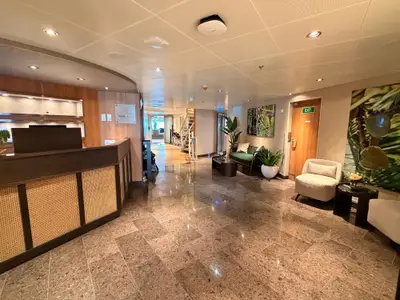 Rezeptionsbereich des Wellnessbereichs an Bord der Seabourn Quest mit elegantem Tresen, Sesseln und Marmorboden.
