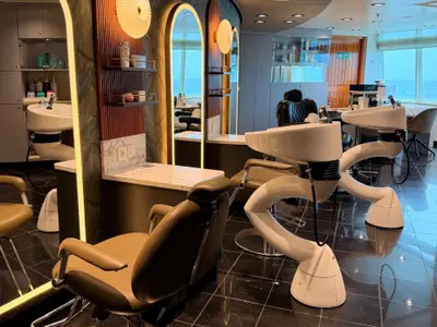 Der elegante Friseursalon an Bord der Seabourn Quest zeigt moderne Waschbecken, bequeme Behandlungsstühle und einen weiten Blick auf das offene Meer.