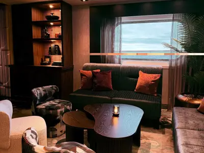 Elegant eingerichteter Wohnbereich in einer Suite an Bord der Seabourn Quest mit Sofa, Sesseln und Meerblick durch ein großes Fenster.