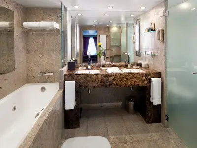 Luxuriöses Badezimmer an Bord der Seabourn Quest mit einem Marmor-Doppelwaschtisch, Badewanne und einer Dusche.
