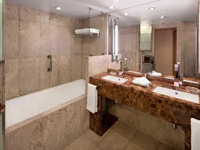 Blick in das luxuriöse Badezimmer mit Doppelwaschtisch und Badewanne an Bord der Seabourn Quest.