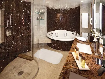 Das elegante Badezimmer einer Wintergarden Suite an Bord der Seabourn Quest bietet einen Whirlpool, eine Dusche und edle Mosaikfliesen.