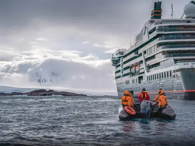Passagiere im Zodiac-Schlauchboot fahren in der Antarktis nahe dem Expeditionsschiff Seabourn Venture.