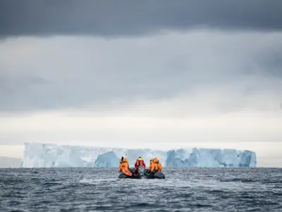 Gäste der Seabourn Venture fahren in einem Zodiac-Schlauchboot auf ein Eisfeld in der Antarktis zu.