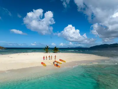 Gäste bei einem Kajak-Landausflug an Bord der Seabourn Venture auf einer kleinen tropischen Sandinsel in der Karibik.