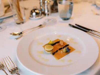Nahaufnahme eines elegant angerichteten Lachsgerichts mit Kaviar und Blinis an Bord der Seabourn Venture.
