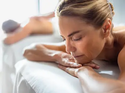 Eine Frau entspannt sich mit geschlossenen Augen während einer Massage im Spa an Bord der Seabourn Venture.