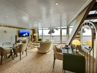 Eine elegante Duplex-Suite an Bord der Seabourn Venture mit stilvoller Einrichtung und Panoramablick auf polare Eisberge.