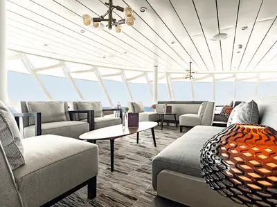 Die helle X-Lounge an Bord der Mein Schiff 1. Moderne Lounge mit grauen Sitzmöbeln und Tischen. Große Fenster bieten weiten Blick auf das Meer.
