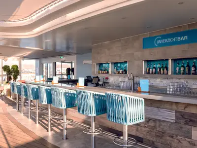 Blick in die moderne Unverzicht Bar an Bord der Mein Schiff 1. Eine lange Theke mit blauen Barhockern und Panoramafenstern zur Landschaft ist zu sehen.