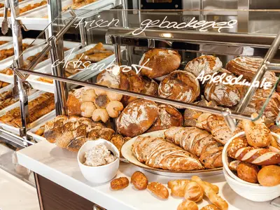 Nahaufnahme eines Buffets mit einer grossen Auswahl an frisch gebackenem Brot, Brötchen und Gebäck in einem Restaurant an Bord der Mein Schiff 1.