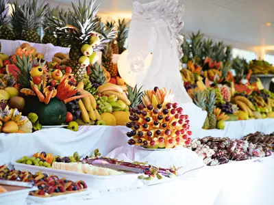 Üppiges Obstbuffet an Bord der Mein Schiff 6. Viele frische Früchte wie Ananas, Melonen und Trauben sind kunstvoll arrangiert. Fokus auf eine Pyramide aus Obstspießen. Ohne Personen.