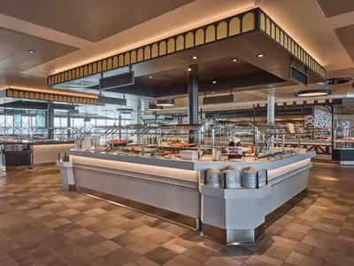 Grosser, moderner Buffetbereich 'Harbour Market' an Bord der Mein Schiff Relax. Reichhaltiges Speiseangebot an mehreren Stationen, inklusive Nutella-Spender. Helle, saubere Einrichtung.
